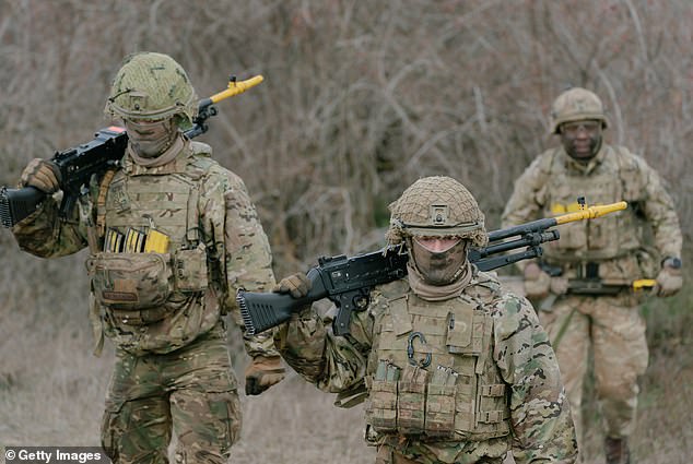 British soldiers walk back to their vehicles at the end of an exercise on February 17, 2025 in Smardan, Romania