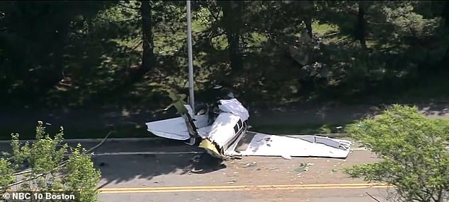 Images from the scene in Beverly, Massachusetts, show the plane laying crumpled against a utility pole, across a street surrounded by leafy woodland on either side