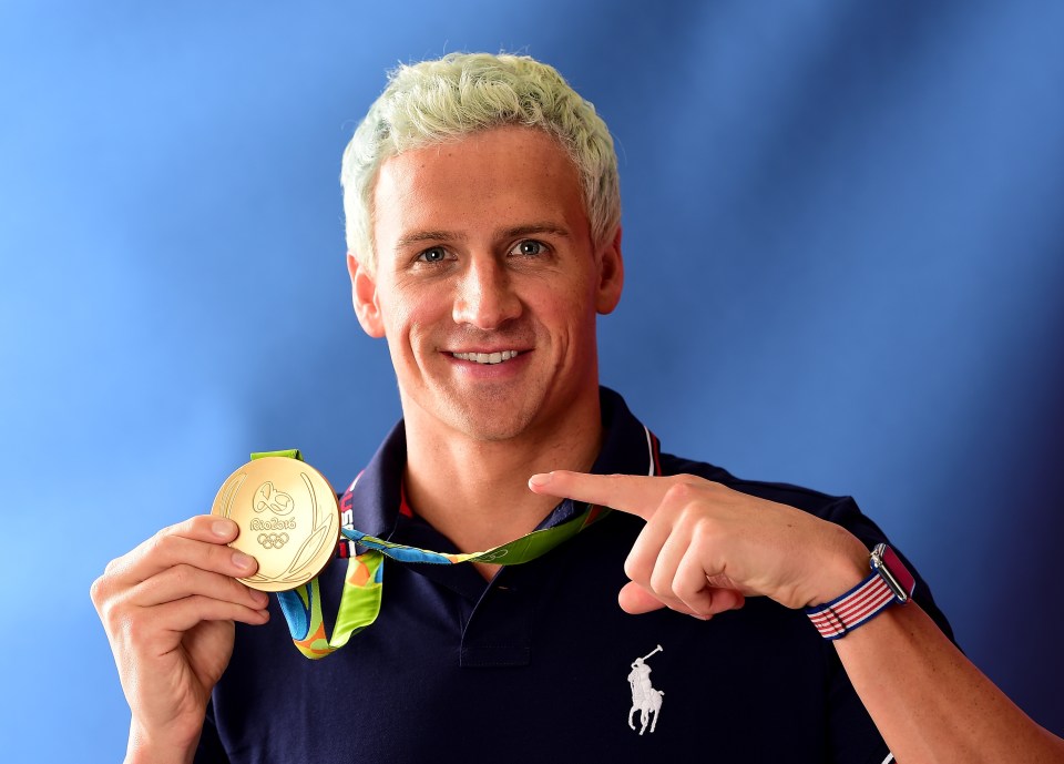Ryan Lochte holding his gold medal.