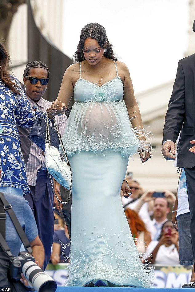 Pregnant Rihanna, 37, showed off her growing baby bump in a mesh gown as she attended the global premiere of the Smurfs movie in Belgium on Saturday