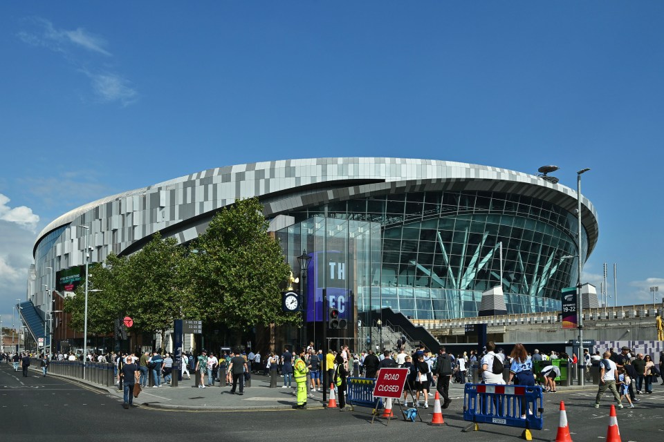 Tottenham Hotspur Stadium exterior with fans outside.