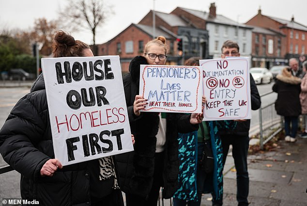 A worried group gather in Manchester in November 2024 with a sign to 'House Our Homeless FIrst' in protest against asylum seekers being housed locally