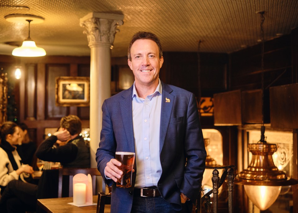 Simon Dodd, CEO of Young & Co Brewery, holding a pint of beer.