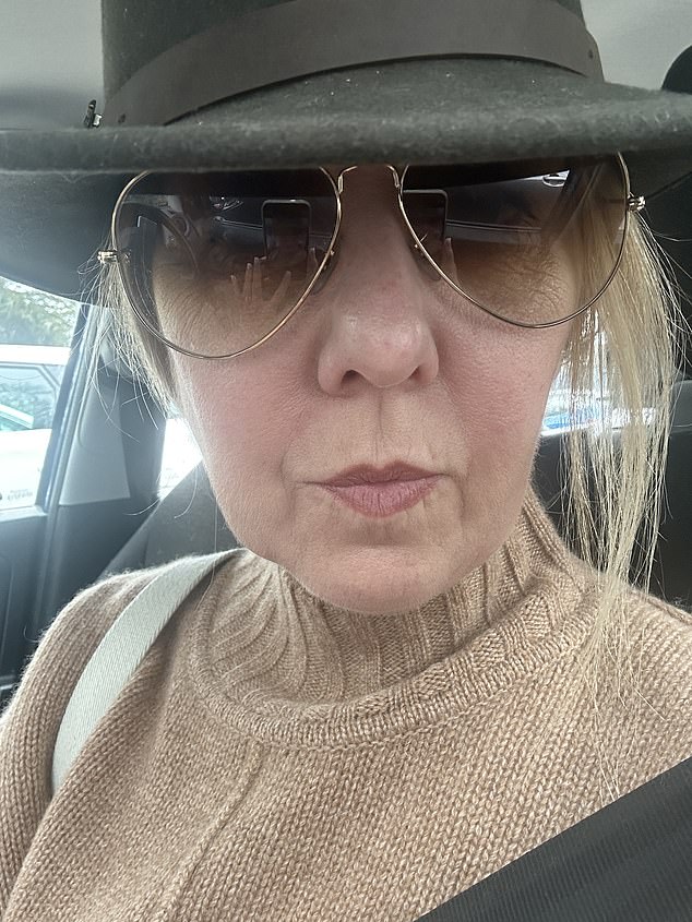 Christine Colbert hides her face beneath a wide-brimmed hat and a pair of oversized sunglasses