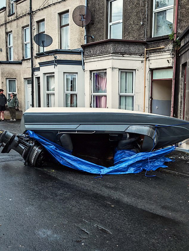 A boat appears upside down on a street in the area amid the riots, with smashed glass on the floor