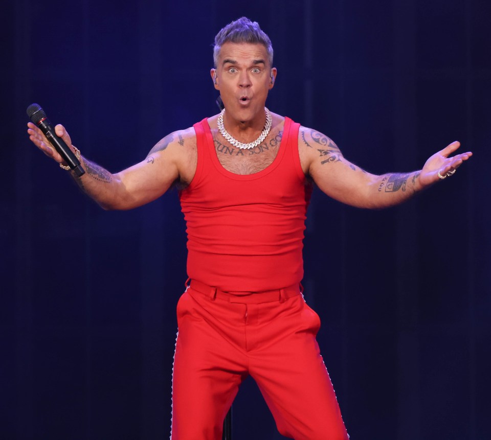 Robbie Williams performing on stage.