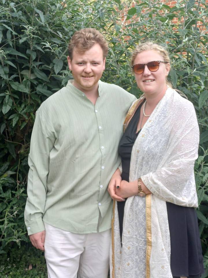 Photo of a man and woman standing together outdoors.