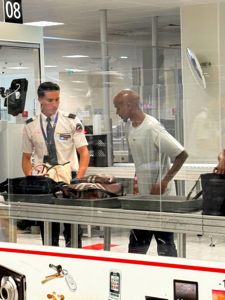 Sir Mo Farah at airport security with a large award.