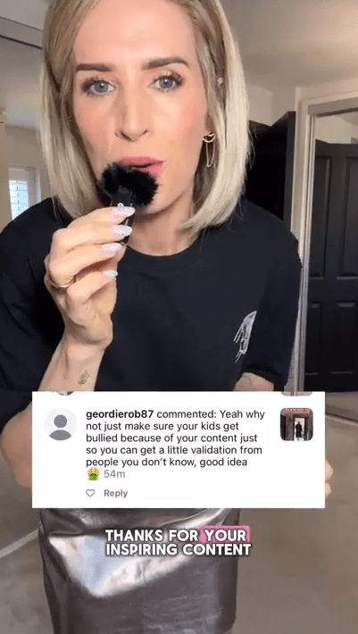Woman holding a makeup brush and reading a comment.