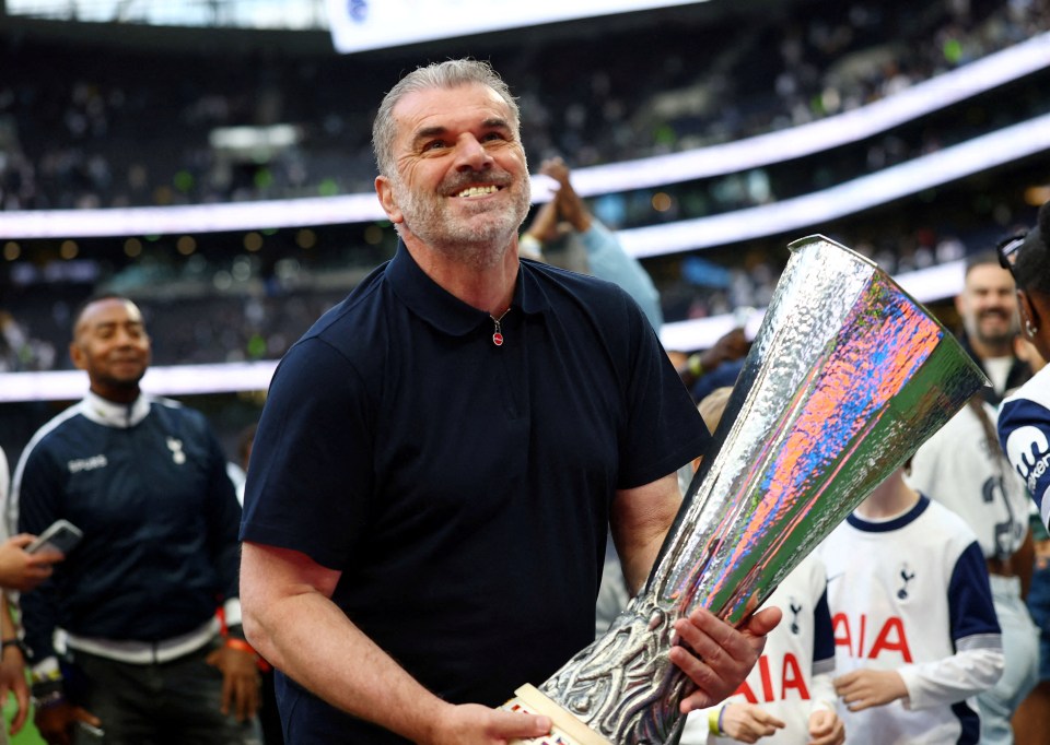 Ange Postecoglou holding the Europa League trophy.