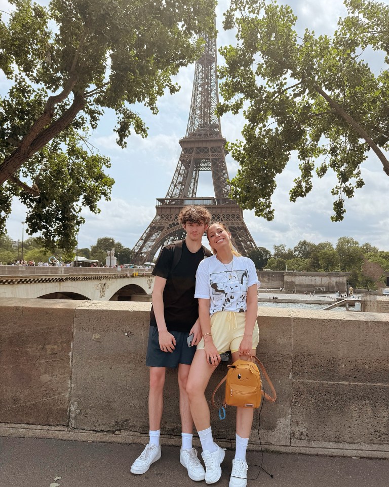 Two people posing in front of the Eiffel Tower.