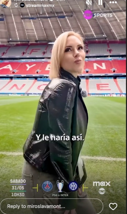 Woman in black leather jacket at a soccer stadium.
