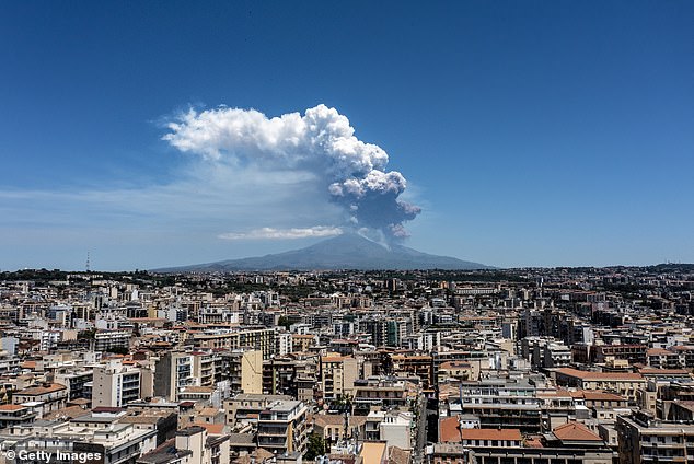 Mount Etna exhibits a Strombolian eruption, with a volcanic plume rising from the southeast crater