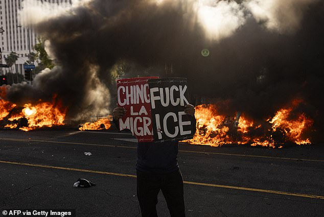 Trump sent 2,000 National Guard troops into the city to disperse protesters (pictured, a protester holding a sign reading 'f*** ICE)