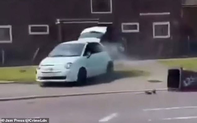 This is the shocking moment a damaged Fiat 500 was spotted reversing erratically down a road with its boot open during riots in Salford