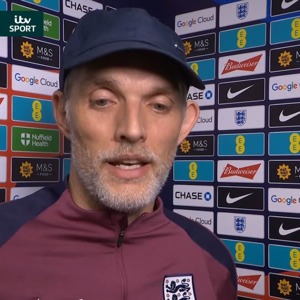 Man in England tracksuit giving interview.