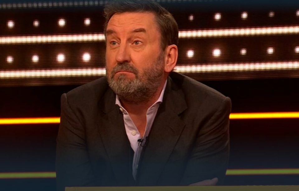 A man in a suit looks thoughtfully at something off-camera.