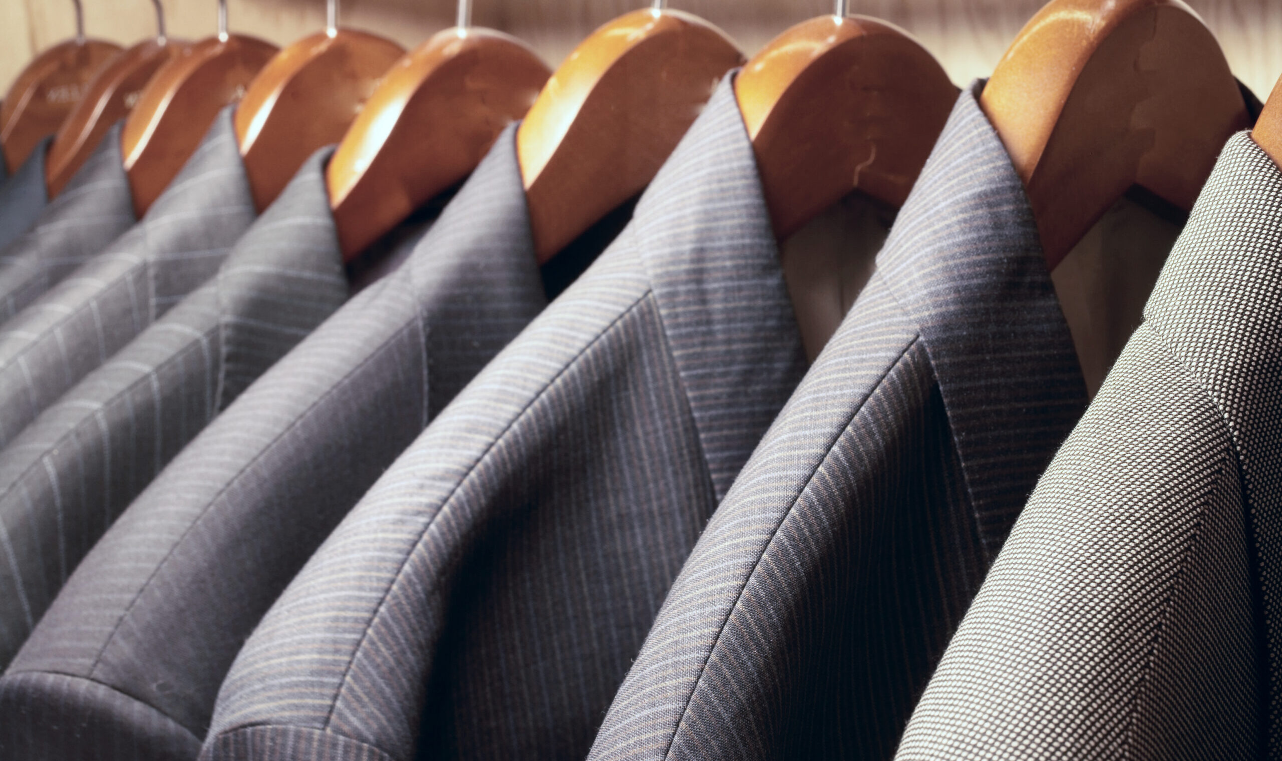 Row,Of,Men's,Suit,Jackets,Hanging,In,Closet