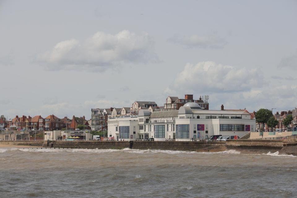 Photo of Bridlington, England, showing a seaside town with buildings and a beach.