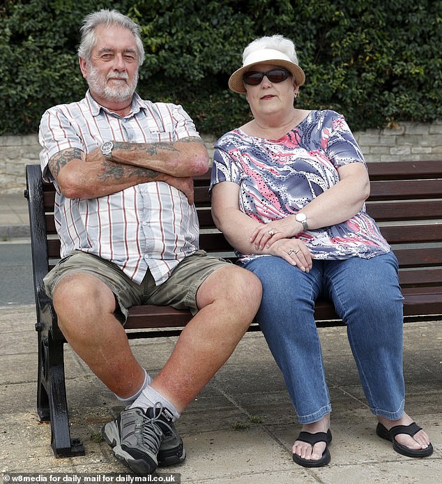 Local residents Steve and Sue Bromley sit on a bench outside the Ocean Hotel