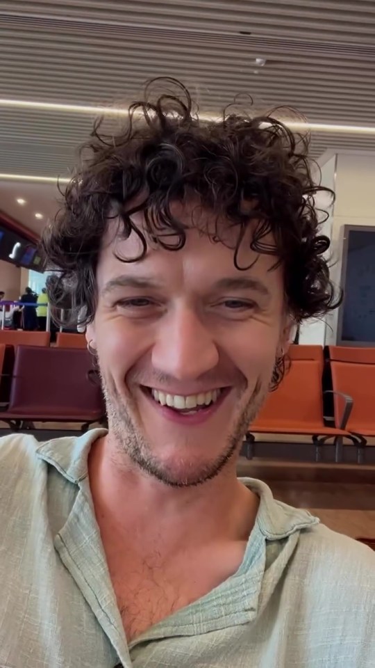 Man smiling at the airport before a flight.