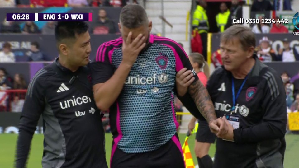 Injured soccer player being assisted by two coaches.
