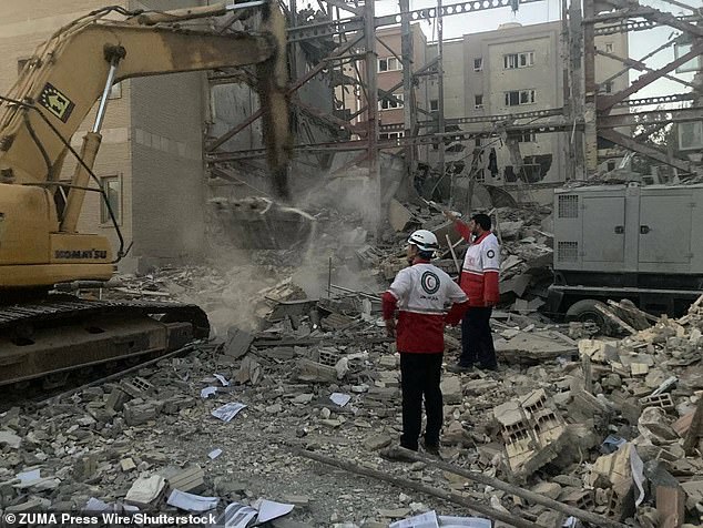 Iran and Israel have been trading missiles since last Friday. Pictured: Members of the Iranian Red Crescent rescue teams are clearing debris from a building that was destroyed during an Israeli attack in Tehran