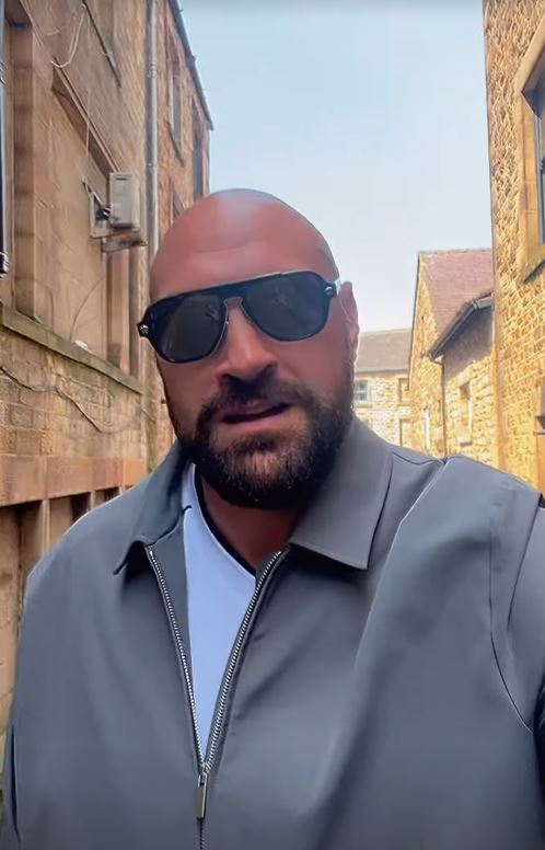 Tyson Fury in a gray jacket and sunglasses.