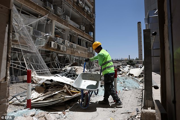 A worker cleans debris at the Soroka hospital complex after it was hit by an Iranian missile in Beer Sheva, southern Israel, 20 June 2025. Israel and Iran have been exchanging fire since Israel launched strikes across Iran on 13 June 2025 as part of Operation 'Rising Lion.'