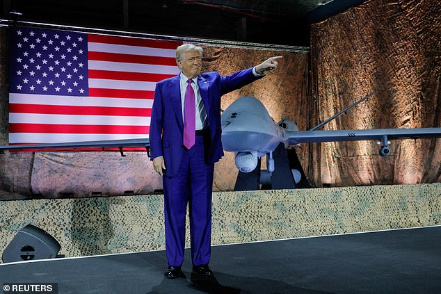 Donald Trump gestures while delivering remarks to U.S. troops, next to a drone and a U.S. flag, during a visit to Al Udeid Air Base in Doha, Qatar, May 15, 2025