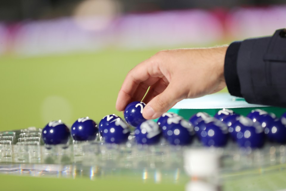 Hand selecting a numbered ball from a group of balls for a draw.