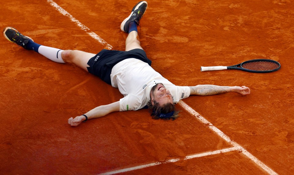 Alexander Bublik celebrates a tennis match victory.