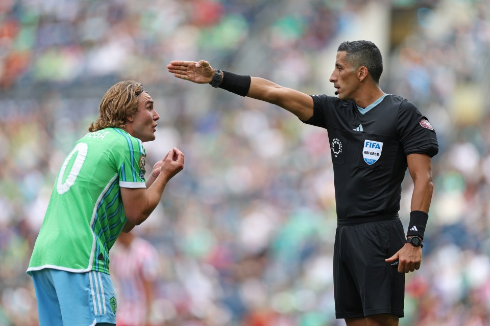 Soccer referee signaling to a player.