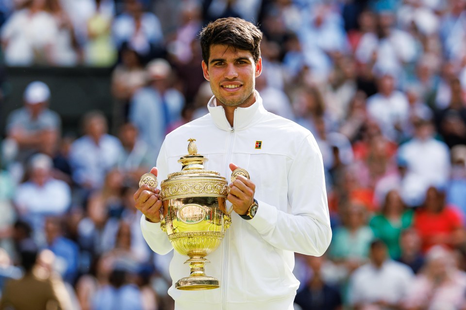 Carlos Alcaraz holding the Wimbledon Gentleman's Singles Trophy.