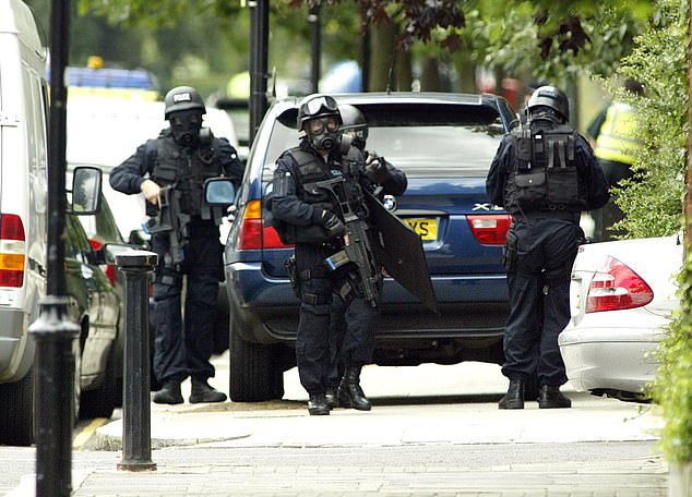 Armed police prepare to raid flats where the terrorist suspects were believed to be hiding