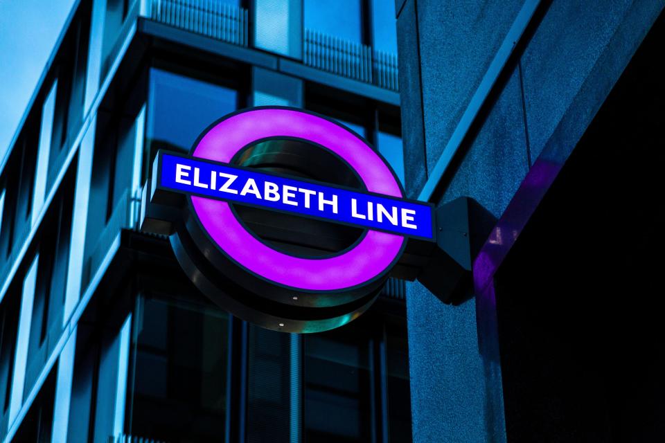 Illuminated Elizabeth Line sign at night.