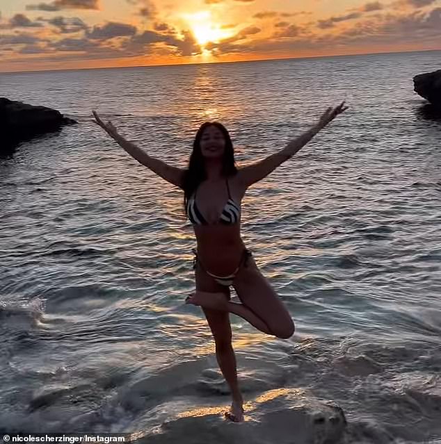The camera moved around behind Nicole to offer a scenic view of the orange sun setting far off in the horizon