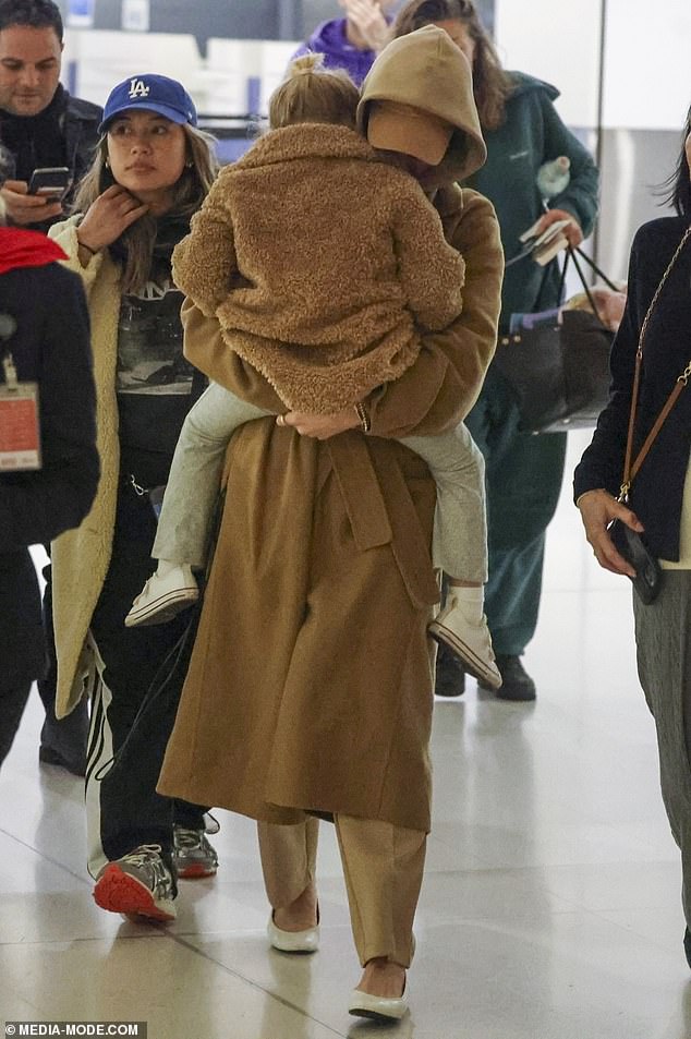 Once sheltered from the storm outside, Katy continued to carry her daughter as she headed for her flight