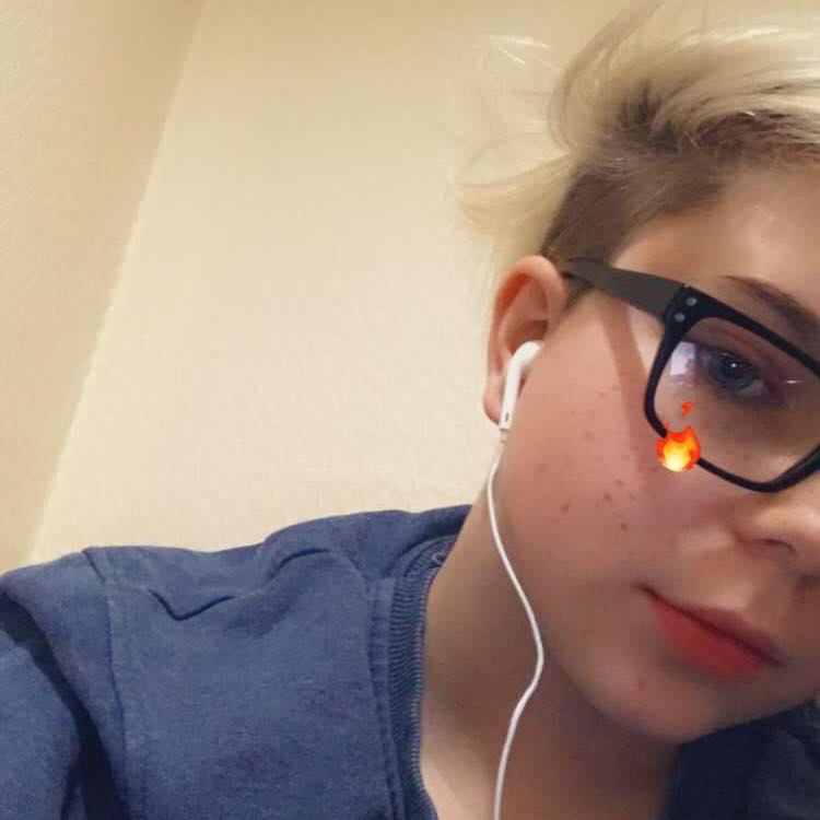 Close-up of a person wearing glasses and earphones.