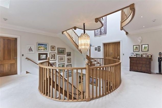 The sweeping staircase (pictured) leads to the first floor's 'impressive main bedroom suite with a bespoke fitted dressing room and balcony overlooking the rear garden'