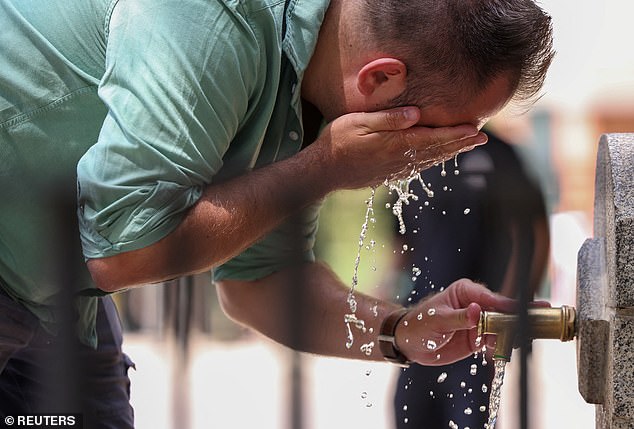 Pictured: A man cools off at a fountain at Retiro park during a heatwave, in Madrid, Spain, July 1, 2025