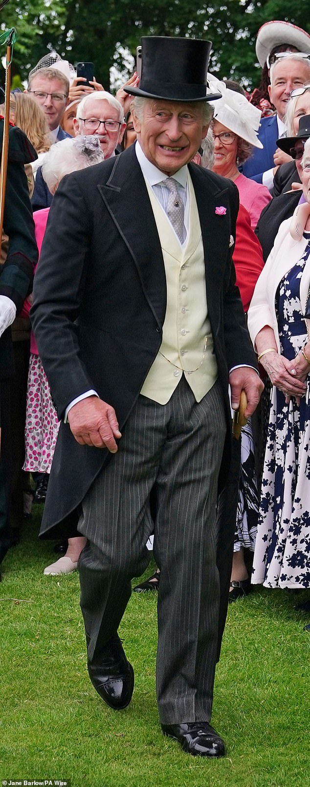 Charles added a bright pink floral pin to his long, black tailcoat for Tuesday's garden party in Scotland