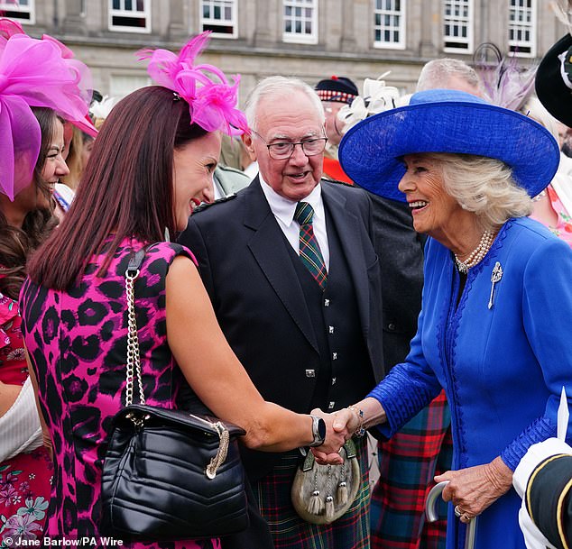 Queen Camilla appeared delighted as she shook hands with attendees during today's garden party