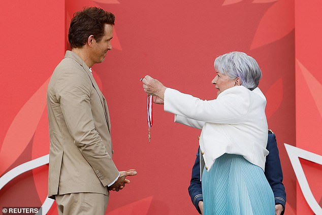 Putting on a brave face, Blake looked to be in high spirits as she snapped photos of Ryan while Canada's Governor General Mary Simon placed the medal around his neck