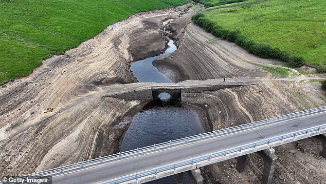 Low water levels at Baitings Reservoir reveal an ancient pack horse bridge in Ripponden yesterday