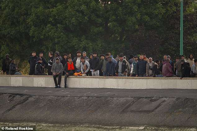 Nearly 900 arrived in Dover from France on Monday, the latest official figures revealed. Pictured: Migrants waiting to board a small boat in Gravelines, France, today