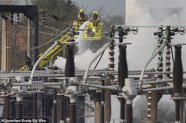 Firefighters spray foam onto the smouldering North Hyde substation in March 21