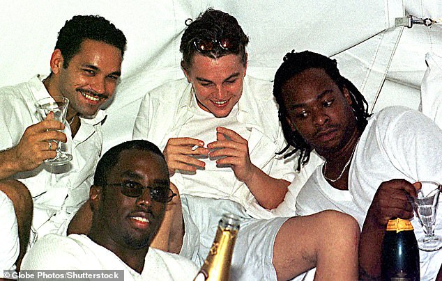 Diddy [front center] and Leonardo DiCaprio [back center] pose for pictures at Combs' White Party in 1998