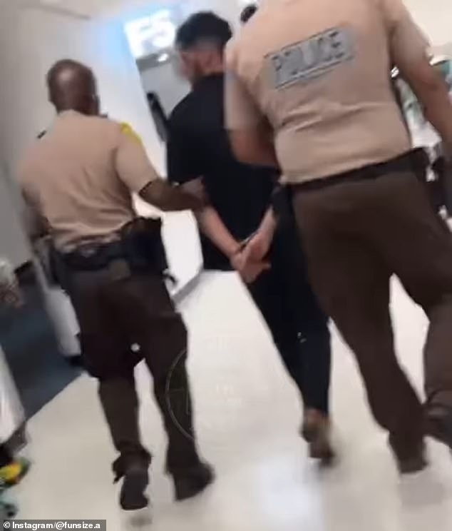 Sharma was marched off the plane in handcuffs by deputies and taken to Jackson West Hospital for treatment before being booked into custody