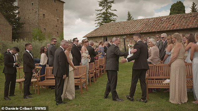 As she readies herself to walk down the aisle Shayna's father, Rob McHugh, 60, approaches wedding guests' before pulling a man from the crowd